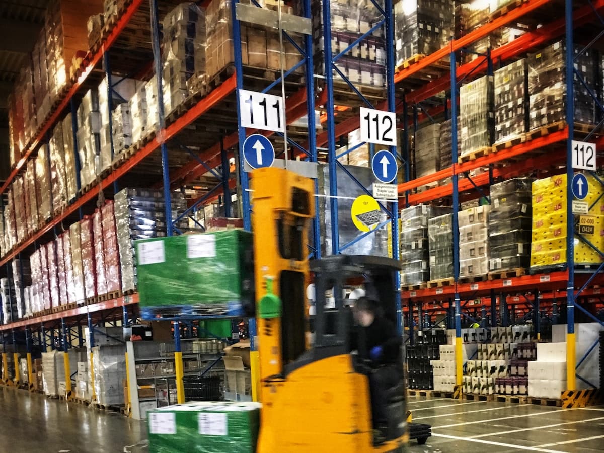 Forklift handling palletised cargo in a warehouse.